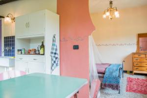 a kitchen and dining room with a pink wall at Casa Luna in Prunetto