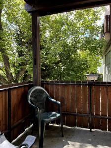 a green chair sitting on the back porch at Große Wohnung mit Billardtisch in Starnberg +10 photos