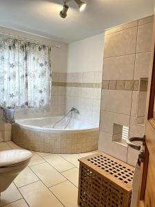 a bathroom with a tub and a toilet and a sink at Große Wohnung mit Billardtisch in Starnberg