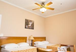 a bedroom with two beds and a ceiling fan at The Durban Hotel Guyana INC. in Georgetown