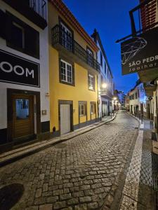 a cobblestone street in a town at night at Pretas Village Flats in Funchal
