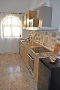 a kitchen with a sink and a stove top oven at NiAmalFi Apartments in Atsipopoulo