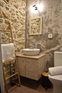 a bathroom with a sink and a stone wall at NiAmalFi Apartments in Atsipopoulo