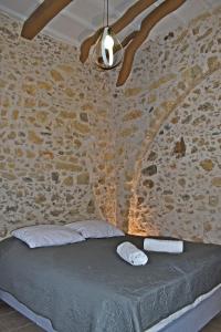 a bedroom with a bed in a stone wall at NiAmalFi Apartments in Atsipopoulo