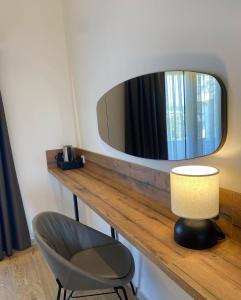 a table with a mirror and a chair and a lamp at Hotel Comfort & Villas in Donji &Scaron;toj