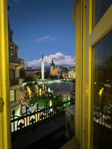 een raam met uitzicht op de stad 's nachts bij Rooms on Europe Square in Batoemi +5 foto's