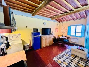 a kitchen with a blue refrigerator and a table at Turquoise Rose Apartment in Peccioli