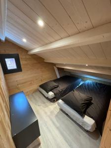 two bunk beds in a wooden room with a table at Chalet Albert in Bolquere Pyrenees 2000