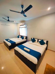 two beds in a room with a ceiling fan at 488, The Nook in Bhubaneshwar +19 photos