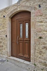 a brown wooden door in a stone wall at NiAmalFi Apartments in Atsipopoulo +18 photos