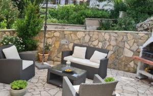 un patio con mobili e una parete in pietra di Apartment Sofia a Mali Lošinj (Lussinpiccolo)