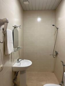 een badkamer met wastafel en douche bij Rooms on Europe Square in Batoemi