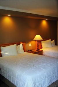 una habitación de hotel con 2 camas y una lámpara en Tea Garden Lodge, en South Lake Tahoe