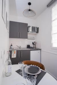 a kitchen with a table with a bottle and a plate on it at Studio hyper centre au calme in Caen