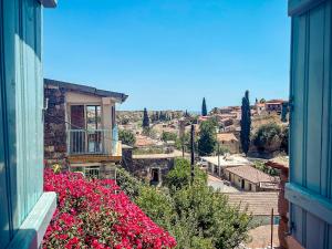 a view of a city from a building with pink flowers at Cyprus Villages Hotel & Restaurant - Central Location - Bed & Breakfast - With Access To Pool And Stunning Views in Tochni