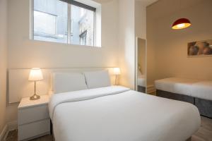 a bedroom with a white bed and a window at Temple Bar Essex Apartments in Dublin