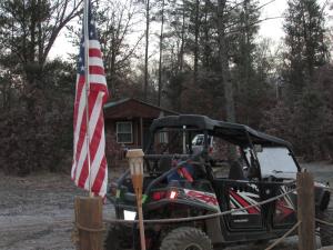 Un ATV con una bandera americana al lado de una casa en Best Bear Lodge, en Irons