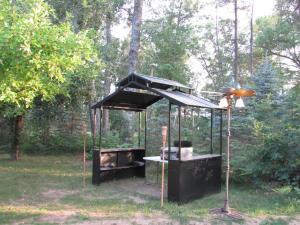 a barbecue grill with a roof in a park at Best Bear Lodge in Irons