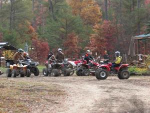a group of people riding atvs on a dirt road at Best Bear Lodge in Irons