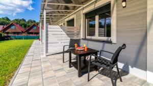 a patio with a table and two chairs on it at Morskie Domki Apartamentowe by PIAMOLA in Sztutowo
