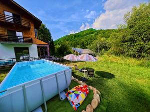 a swimming pool in a yard next to a house at Izvorul lui Dracula in Râşnov