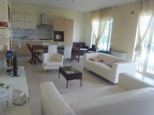 a living room with white furniture and a kitchen at Villa Lancellotti in Agropoli