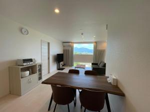 a living room with a wooden table and chairs at GENYA Furano in Nakafurano
