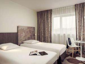 Rúm í herbergi á Mercure Compiègne Sud
