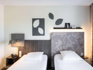 Rúm í herbergi á Mercure Compiègne Sud