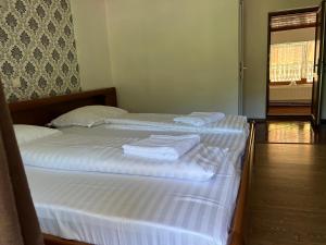 two beds in a room with white sheets and towels at Pensiunea Hanzu Darius in Gura Rîului