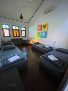 a room with two beds and a living room with windows at Homs Female Hostel in George Town