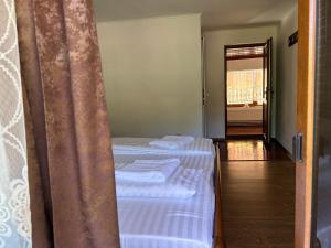 two twin beds in a room with a doorway at Pensiunea Hanzu Darius in Gura Rîului