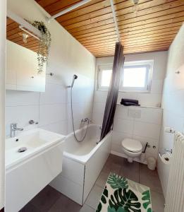 a bathroom with a tub sink and a toilet at Sonniges Bodensee-Balkonidyll in Arbon