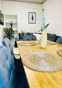 a living room with a table and blue chairs at SH-Apartments-Stylische FeWo Mia - Parken - Wifi in Schmalkalden
