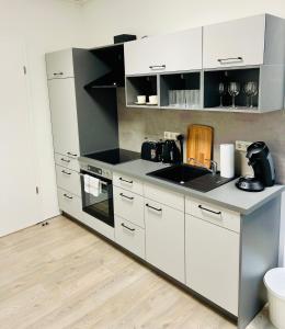 a kitchen with white cabinets and a counter top at SH-Apartments-Stylische FeWo Mia - Parken - Wifi in Schmalkalden