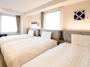 two beds in a hotel room with windows at Comfort Hotel Nagoya Kanayama in Nagoya +35 photos