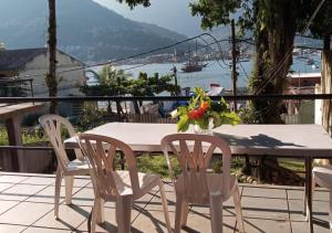 a table and chairs on a balcony with a view at Casa das orquídeas ilha de Itacuruça in Itacuruçá