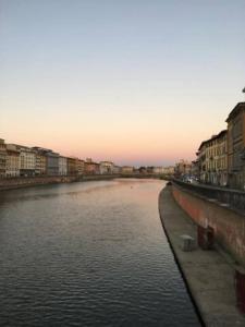 a view of a river in a city with buildings at Suite storica e panoramica - Centro in Pisa