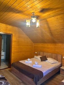a bedroom with a bed with two towels on it at Casa Favorit in Costeşti