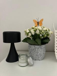 Ein Schmetterling sitzt auf einer Vase mit Blumen und einer Kerze. in der Unterkunft Studio Δωμάτιο in Eretria