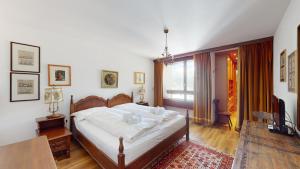 a bedroom with a bed and a table and a television at Abitaziun St Moritzerhof 61 - St Moritz in St. Moritz