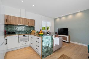 a kitchen with white cabinets and a living room at Comeback LA CASA OCULTA DE LA LUNA in Salobreña