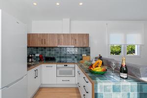 a kitchen with white cabinets and a bowl of fruit on a counter at Comeback LA CASA OCULTA DE LA LUNA in Salobreña +22 photos