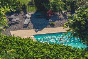 an overhead view of a swimming pool with chairs and trees at Logis Hôtel Restaurant Le Plantevin in Propiac