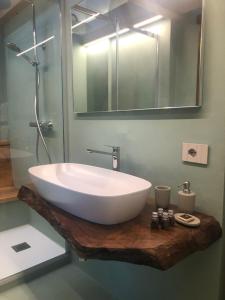 a bathroom with a large white sink on a wooden counter at TROIS COURONNES - GRANDE ROCHERE Appartamento di Charme a La Salle Valle d'Aosta in La Salle +27 photos