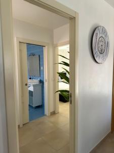 a door leading into a hallway with a clock on the wall at Ocean Breeze guesthouse in Nazaré