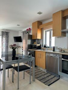 a kitchen with stainless steel appliances and a table at Ocean Breeze guesthouse in Nazaré