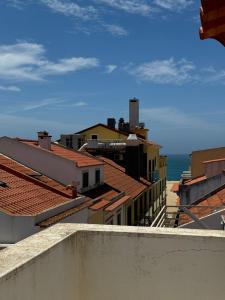 a view of the roofs of buildings and the ocean at Ocean Breeze guesthouse in Nazaré