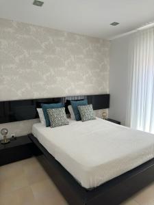 a bedroom with a large white bed with blue pillows at Ocean Breeze guesthouse in Nazaré