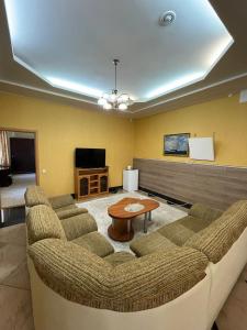 a living room with a couch and a table at Shanyrak Hotel in Temirtaū